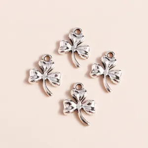 Macro detail of four silver-plated shamrock clover charms with vintage textured finish