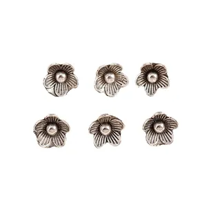 Six retro silver alloy flower charms for DIY jewelry making on white background