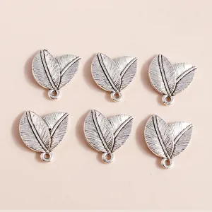 Macro detail of antique silver leaf charms showing intricate vein texture and rings