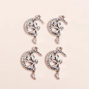 Macro detail of retro silver moon and fairy pendants for DIY jewelry making accessories