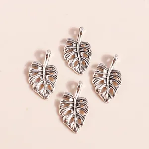 Macro detail of antique silver plated hollow Monstera leaf pendants for DIY jewelry making