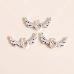 Close-up of three silver hollow heart wing pendants for DIY jewelry making accessories
