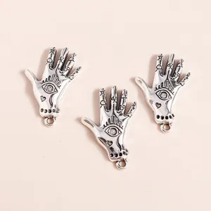 Macro shot of silver alloy Hamsa hand pendants with eye pattern and crystal inlay