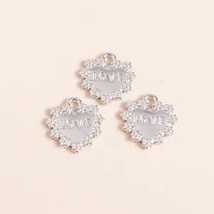 Macro view of silver plated alloy heart charms with LOVE engraving and lace edge