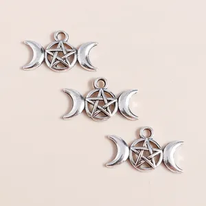 Macro shot of silver alloy triple moon and pentagram charms for DIY jewelry making