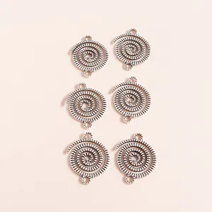 Set of six silver plated spiral alloy pendants with vintage finish on pink background