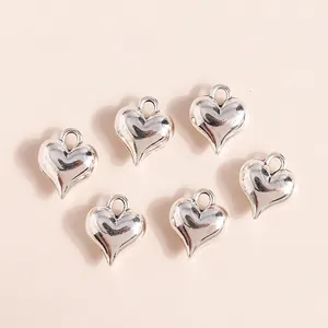 Set of 3D metallic silver heart pendants for DIY jewelry making on cream background