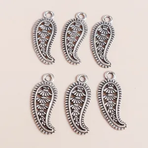 Detailed view of six vintage silver feather pendants with paisley texture and hanging loops