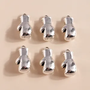 Macro detail of six silver boxing glove pendants arranged in a neat grid on beige