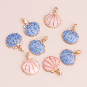 Macro detail of shell-shaped alloy pendants with blue and pink enamel and gold loops
