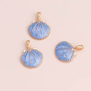 Three light blue enamel shell pendants with gold alloy borders on pink background