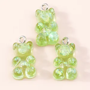 Close-up of translucent light green resin gummy bear charms with sparkly sequins