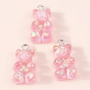 Detailed view of three pink resin gummy bears with sparkly aurora sequins and silver loops
