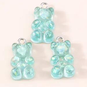 Three mint green resin gummy bear pendants with iridescent sequins and silver loops