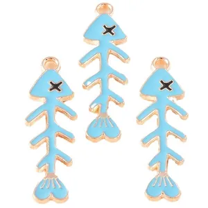 Three cute light blue enamel fish bone alloy pendants with gold-plated finish on white background