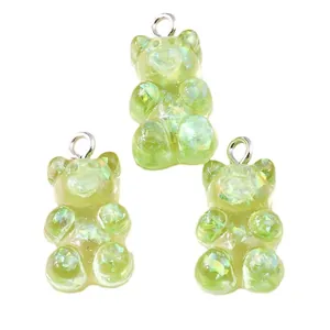Three green resin gummy bear pendants with aurora sequins and silver jump rings