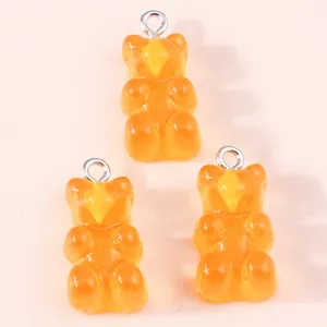 Three orange translucent resin gummy bear charms with silver rings for DIY jewelry making