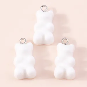 Macro detail of three white resin gummy bear charms with silver metal rings for DIY