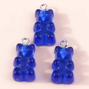 Macro detail of three dark blue resin gummy bear pendants with silver metal loops