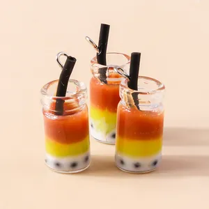 Macro-opname van drie kleuren gradiënt mini bubble tea bedeltjes met rietjes en ringetjes