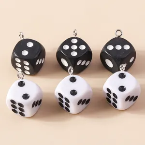 Gros plan de breloques dés en acrylique noir et blanc avec anneaux en métal pour bijoux