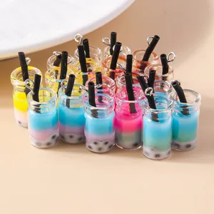 Macroshot van kleurrijke miniatuur bubble tea bedeltjes met harsvloeistof en zilveren lussen