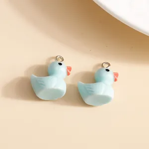 Close-up of two light blue resin duck pendants with silver metal loops for DIY jewelry