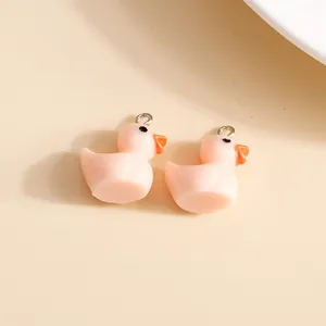 Detailed view of pink resin duck charms with silver metal rings for DIY jewelry making