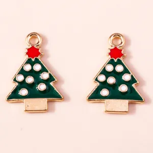Detail of green enamel Christmas tree alloy charms with red stars and gold metal edges