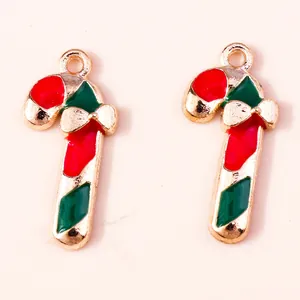 Close-up of red and green enamel Christmas candy cane charms with gold bow accents