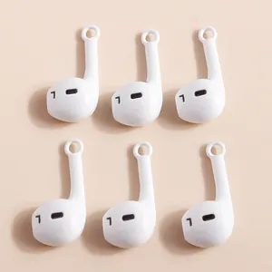Detailed macro view of white headphone-shaped charms with L mark for DIY jewelry making