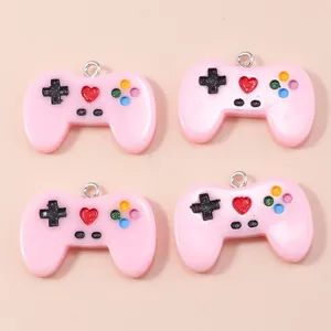 Detailed top view of four pink resin game controller charms with metallic rings