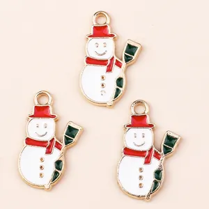 Three gold-plated enamel snowman charms with red hats and green brooms for DIY jewelry making