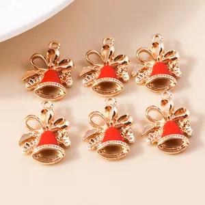 Detail of red enamel Christmas bell charms with gold-plated bows for DIY jewelry making