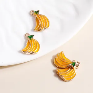 Three vibrant banana charms in yellow enamel with gold metal loops for DIY jewelry making