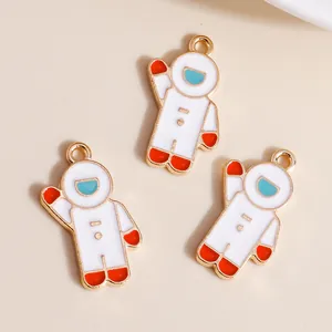 Detailed view of three enamel astronaut charms in gold alloy for DIY jewelry making