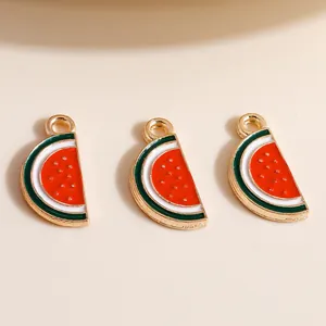 Macro detail of three enamel watermelon alloy charms with golden seeds for DIY jewelry