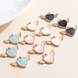 Macro detail of colorful enamel heart wing charms with gold alloy bases for DIY jewelry
