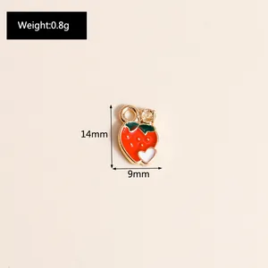 Detail of red strawberry alloy pendant with white heart and rhinestone, size 14mm by 9mm