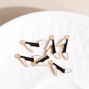 Close-up of black and white enamel high heel charms for DIY jewelry making in a white bowl