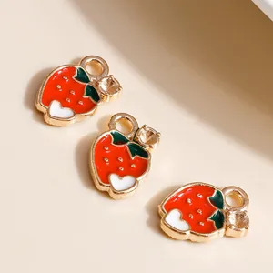 Macro view of strawberry-shaped alloy charms with a green leaf and gold-plated setting