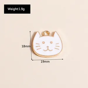 Detail of 18x19mm white enamel cat head charm with golden alloy trim and ring hook