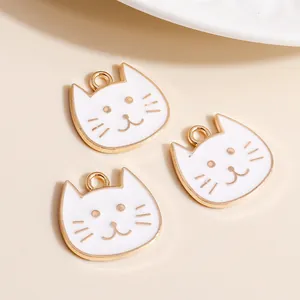 Macro detail of white enamel cat charms with gold alloy edges for DIY jewelry making