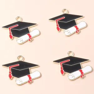 Detail of 4 graduation charms with black academic caps and diploma scrolls in gold alloy