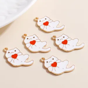 Macro view of five white cartoon cat charms with red hearts and golden hooks