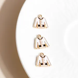 Detailed view of white sweater-shaped charms with pearls and gold-plated alloy finish