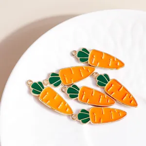 Carrot enamel alloy pendants with green leaf accents on a white textured plate
