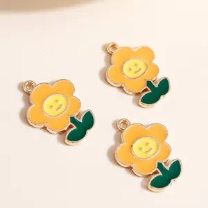 Close-up of enamel flower charms with smiley face details and gold metal edges