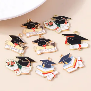 Macro shot of assorted graduation alloy charms with enameled graduate hat and scrolls