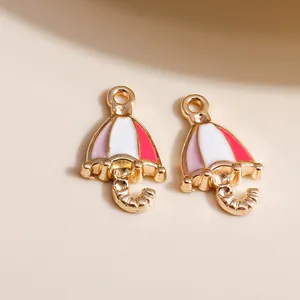 Nahaufnahme von Emaille-Regenschirm-Anhängern in Gold und Rosa für DIY-Schmuckherstellung